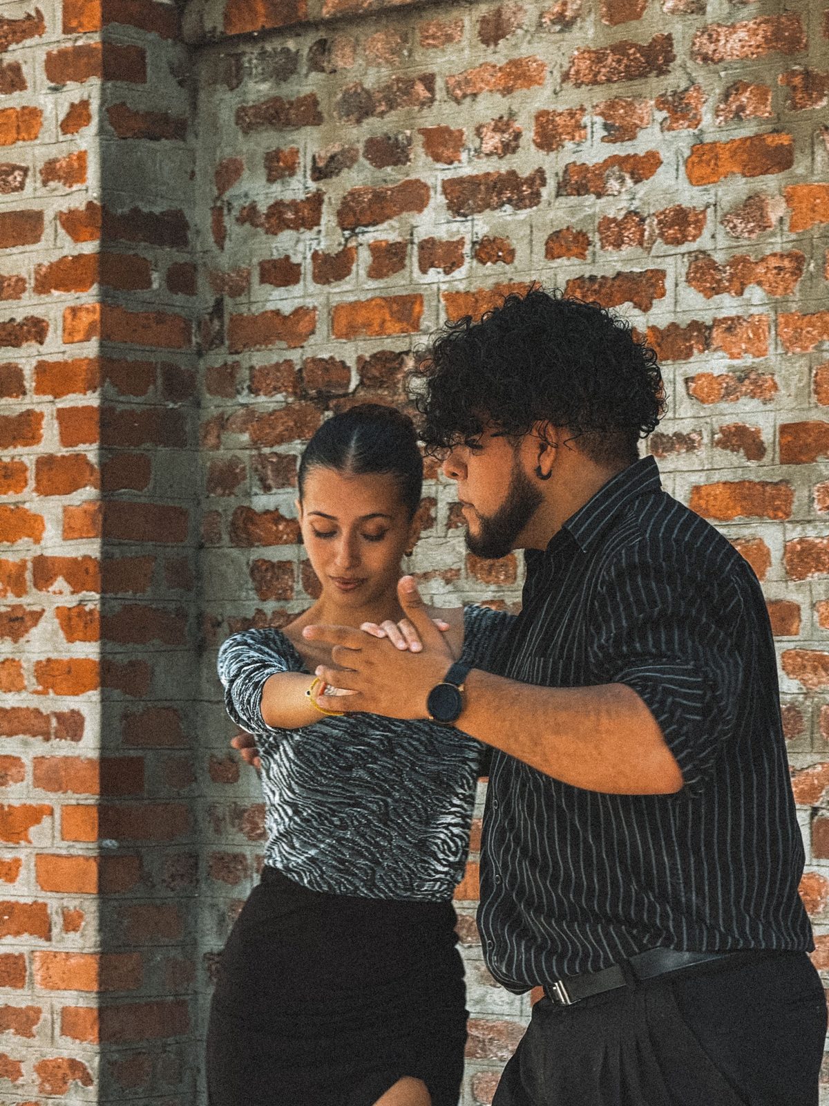 A Salsa teacher guiding a dancer through partner connection